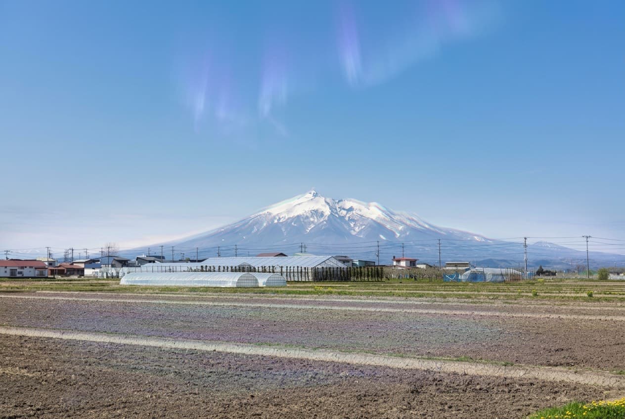 Open fields in Aomori with distant mountain ridges